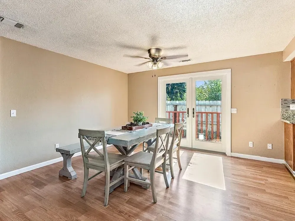 Warm dining space with wood flooring and doors to a deck